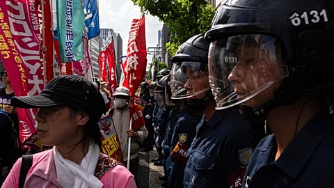 Police officers watch during a protest on the 80th anniversary of the atomic bombing in Hiroshima, Wednesday, Aug. 6, 2025.