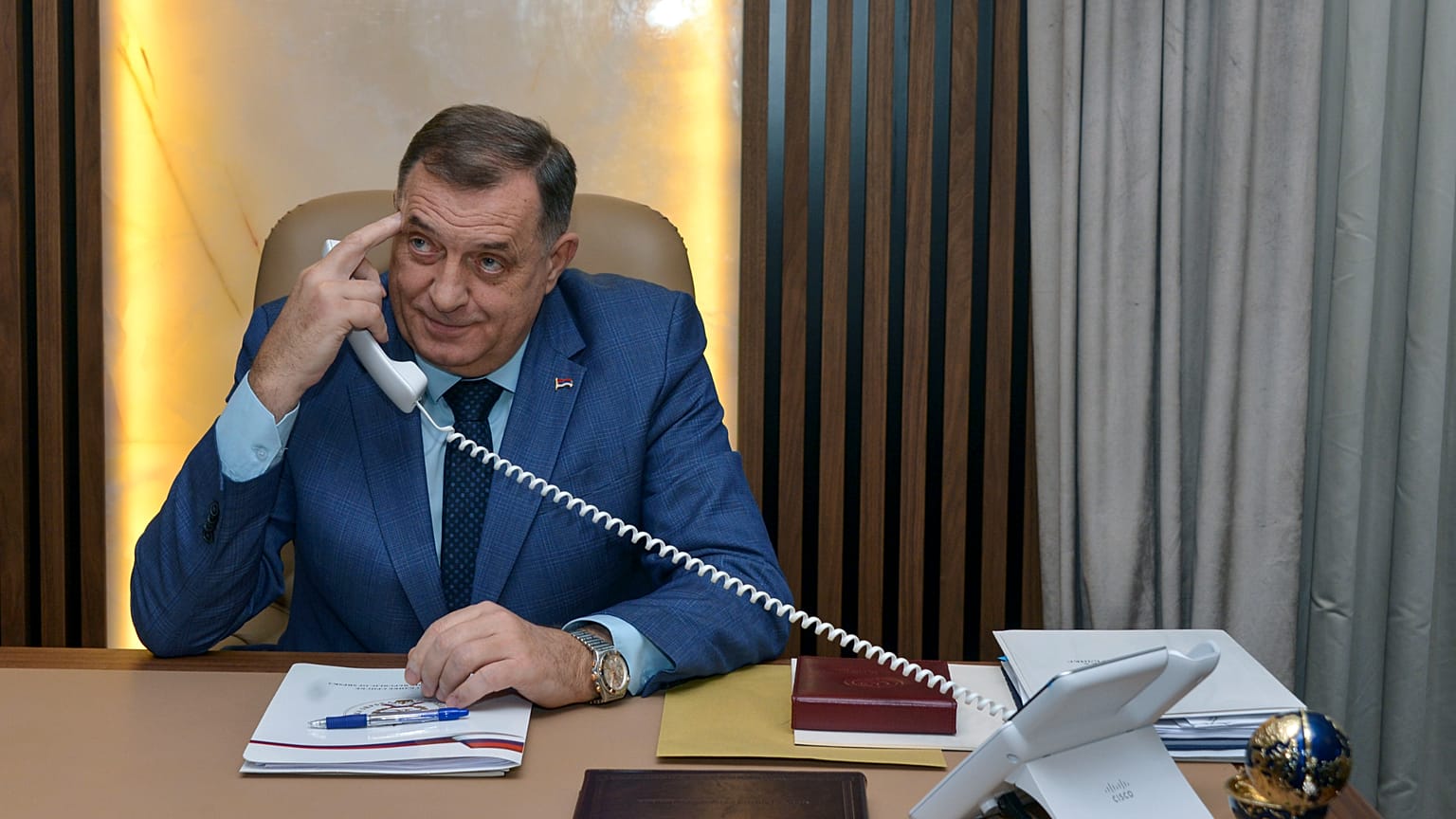 Лидер боснийских сербов Милорад Додик пользуется телефоном в своем офисе в Баня-Луке, 29 декабря 2023 года