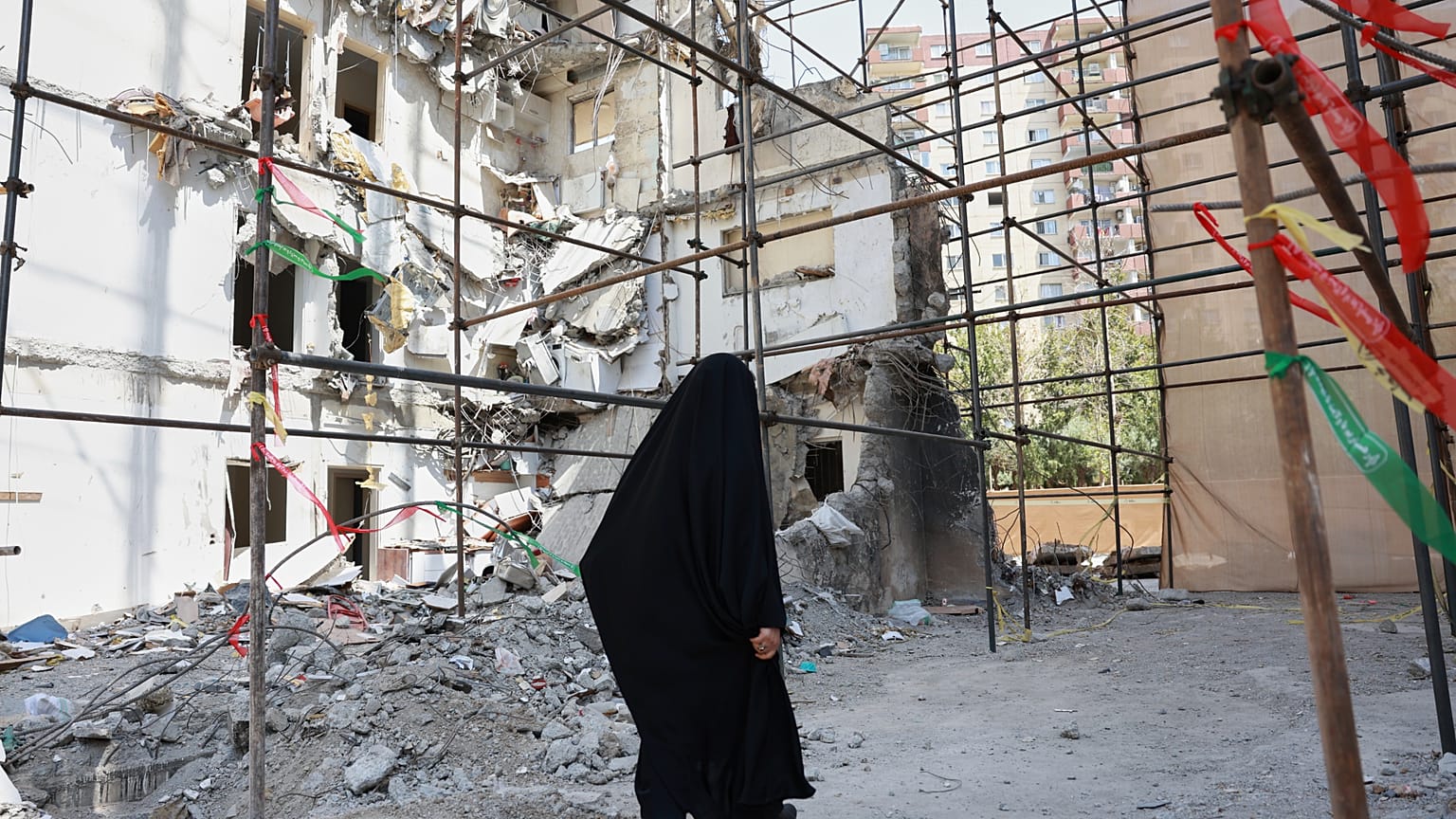 Una mujer pasa junto a un edificio dañado en un letal ataque aéreo israelí del 13 de junio en un complejo residencial en Teherán, Irán, el 19 de julio de 2025. 