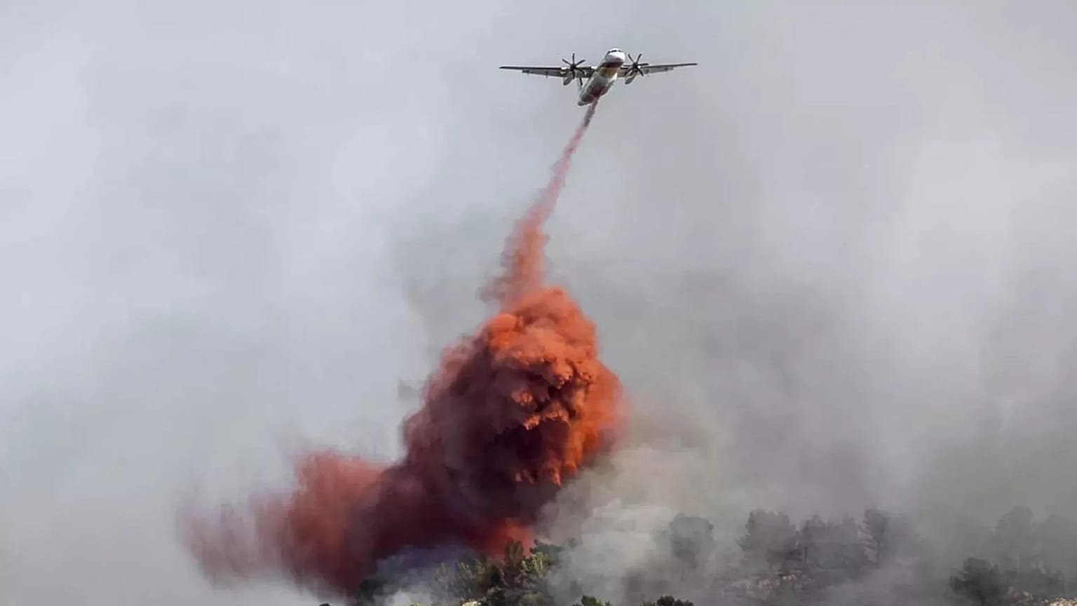 Egy vízibombázó folyadékot szór egy gyorsan terjedő erdőtűzre Franciaország mediterrán régiójában, a spanyol határ közelében, 2025. augusztus 5-én.