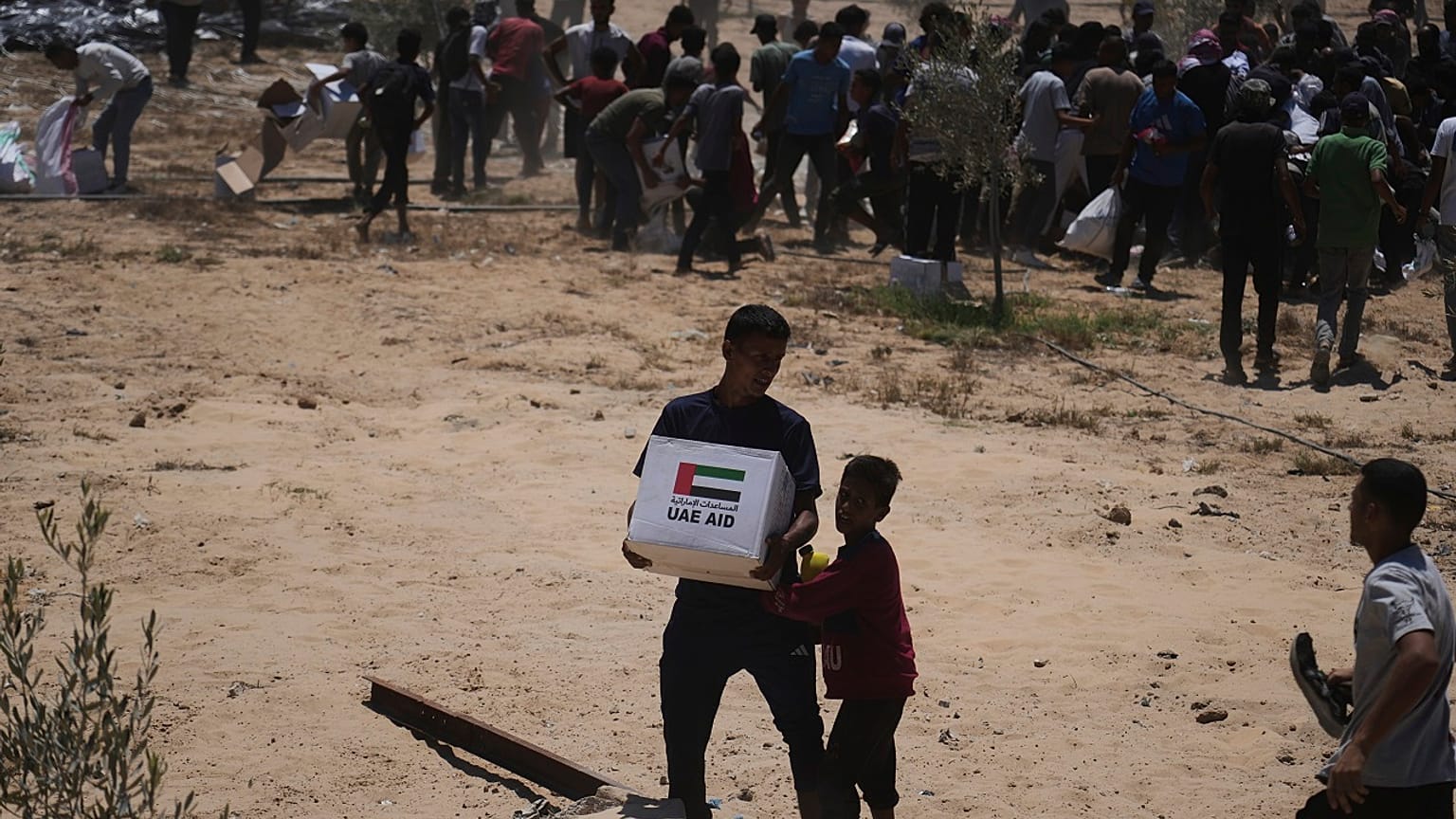 Filistinliler, Birleşik Arap Emirlikleri'nden gelen insani yardım paketlerini Gazze Şeridi'nin orta kesimindeki Deir Al-Balah'a havadan indirildikten sonra topluyor.