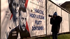 Un fotógrafo ante un cartel de campaña política en Budapest, 9 de abril de 2025.