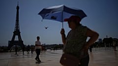 Άνθρωποι περπατούν στην πλατεία Trocadero κοντά στον Πύργο του Άιφελ κατά τη διάρκεια καύσωνα στις 2 Ιουλίου. 