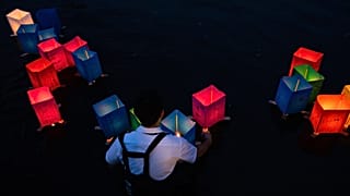 Ein Freiwilliger setzt Papierlaternen auf dem Motoyasu-Fluss vor dem Atombomben-Dom ins Wasser, anlässlich des achtzigsten Jahrestages des Atombombenabwurfs auf Hiroshima, 06.08.2025.