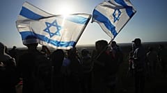 ناشطون من اليمين الإسرائيلي يحملون العلم الإسرائيلي خلال مظاهرة تدعو إلى إعادة إنشاء المستوطنات اليهودية في قطاع غزة. الأربعاء 30 يوليو/ تموز 2025.