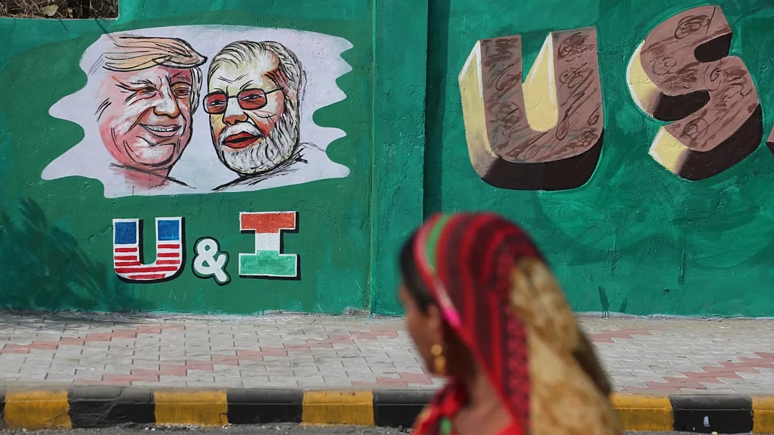 Hintli bir kadın, Trump'ın Şubat 2020'deki ziyareti öncesinde ABD Başkanı Donald Trump ve Hindistan Başbakanı Narendra Modi'nin portreleriyle boyanmış bir duvara bakıyor.