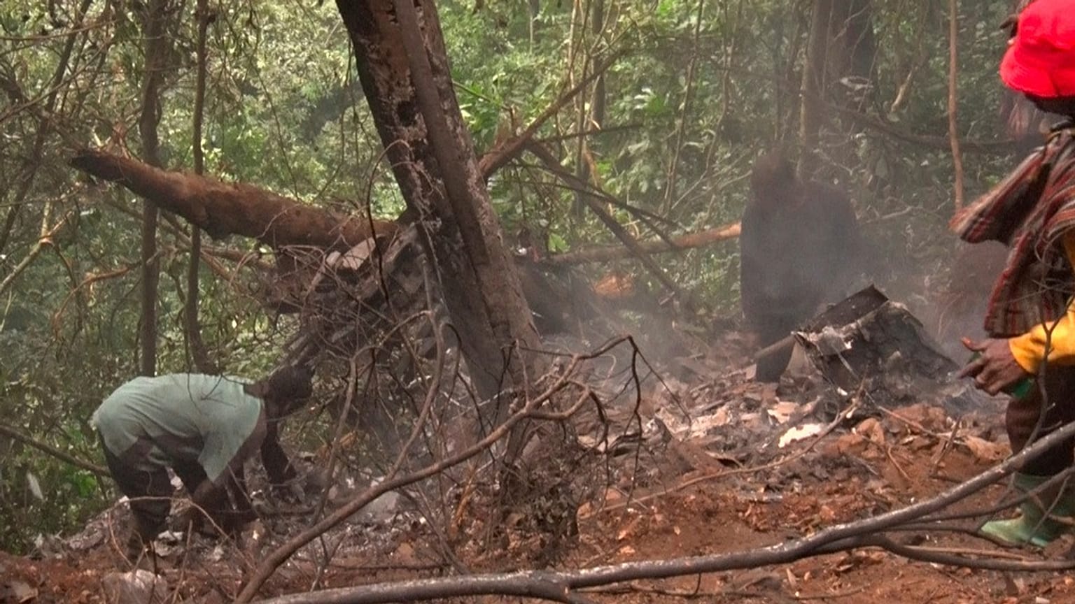 En esta imagen tomada de un vídeo, varias personas trabajan en el lugar donde se estrelló un helicóptero militar en Sikaman, cerca de Adansi, en la región de Ashanti, Ghana, el miércoles 6 de agosto de 2025.