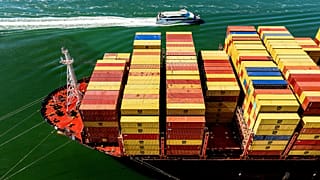 Cargo containers fill a ship at the Port of Oakland, 6 August 2025