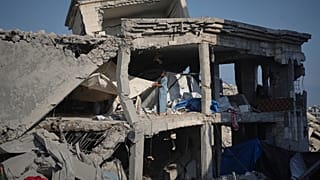 Pessoas inspecionam os danos na clínica da UNRWA Sheikh Radwan al-Taba após o bombardeamento do exército israelita na cidade de Gaza, 6 de agosto de 2025