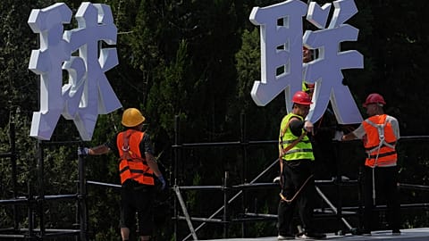 Workers install a platform for a up-coming basketball games event by Chinese sports brand Li Ning at the capital popular commercial district, in Beijing, 6 August 2025.