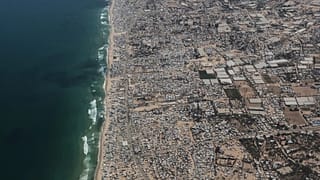 Tendas são vistas na costa da Faixa de Gaza a partir de um avião C-130 da Força Aérea Jordaniana durante um lançamento aéreo de ajuda humanitária, 7 de agosto de 2025