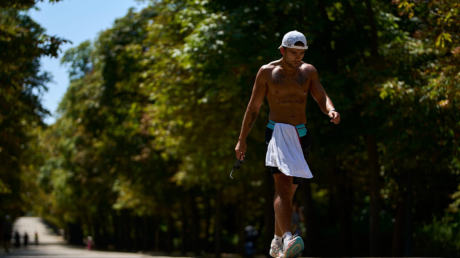Un homme fait de l'exercice dans le parc Retiro par temps chaud à Madrid, Espagne, lundi 4 août 2025.
