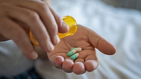 A person takes a pill.