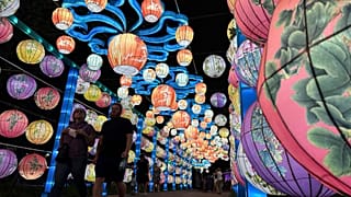 Visitantes percorrem um túnel iluminado no Festival das Lanternas Chinesas de Filadélfia, terça-feira, 5 de agosto de 2025, em Filadélfia