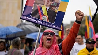 Una simpatizante del expresidente colombiano Álvaro Uribe Vélez marcha para mostrarle su apoyo tras ser condenado a 12 años de arresto domiciliario.