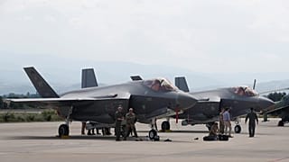 أفراد من الجيش الأمريكي يعملون بالقرب من طائرة مقاتلة من طراز F-35 تابعة للحرس الوطني الجوي في فيرمونت، متوفقة بمطار سكوبيه، مقدونيا الشمالية، في 17 يونيو/ حزيران 2022.
