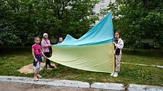 Ukrán gyerekek hazatérő hadifoglyokat köszöntenek Csernihivben 2025. május 24-én