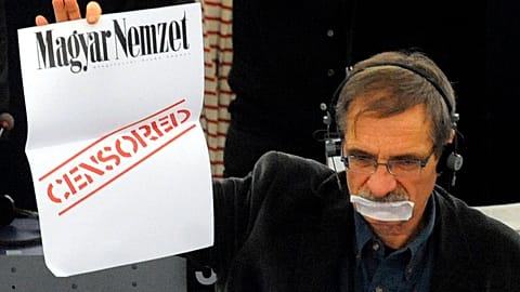 Le député européen français Jean-Paul Besset proteste alors que le Premier ministre hongrois Viktor Orban, invisible, prononce son discours au Parlement européen à Strasbourg, ea
