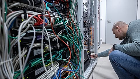 An IT specialist monitoring the servers that manage the hospital's machines.
