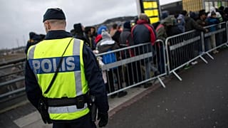Un policier surveille une file d'attente de nouveaux arrivants à la gare de Hyllie, le 19 novembre 2015.