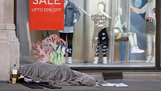 Um sem-abrigo dorme em frente a uma loja de roupa fechada em Londres, 14 de maio de 2020 