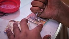رجل فلسطيني يصلح عملة إسرائيلية بالية يوم الأربعاء 9 يوليو 2025 في مدينة غزة.
