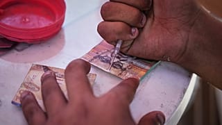 رجل فلسطيني يصلح عملة إسرائيلية بالية يوم الأربعاء 9 يوليو 2025 في مدينة غزة.
