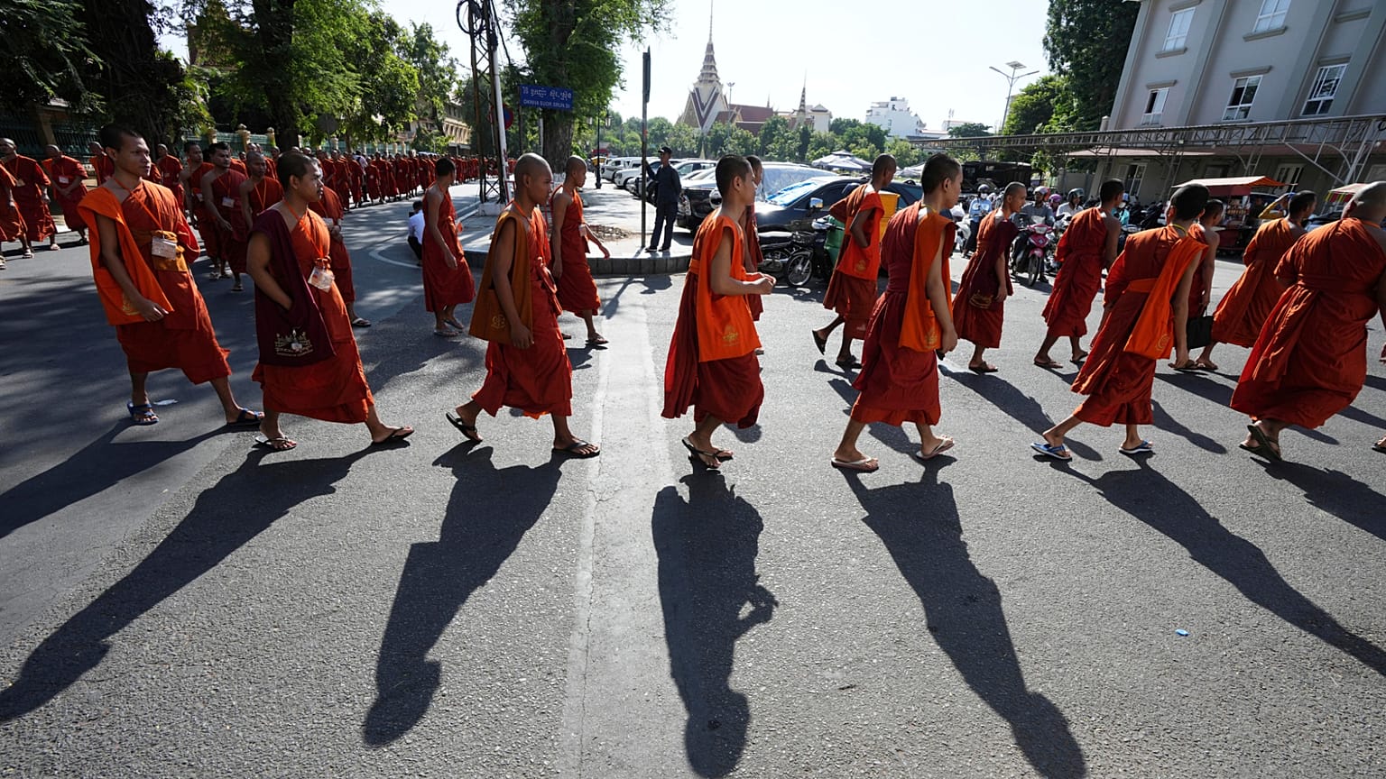 Monges budistas cambojanos marcham numa rua enquanto organizam uma cerimónia para homenagear os soldados mortos em recentes confrontos fronteiriços com as forças tailandesas, no Camboja, na sexta-feira, 8 de agosto de 2025