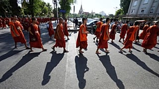 Des moines bouddhistes cambodgiens défilent dans une rue alors qu'ils organisent une cérémonie pour honorer les soldats tués lors des récents affrontements frontaliers avec les forces thaïlandaises, au Cambodge, vendredi 8 août 2025.