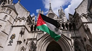 Демонстрант размахивает палестинским флагом у здания Высокого суда в Лондоне, 21 июля 2025 года.
