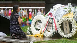 Une femme prie sous la pluie dans le parc de l'Hypocentre de la bombe atomique, alors que le Japon commémore le 80e anniversaire du largage de la bombe atomique, Nagasaki, Japon 08.08.25