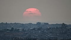 Ο ήλιος δύει πίσω από κτίρια που καταστράφηκαν κατά τη διάρκεια των ισραηλινών επιχειρήσεων στη βόρεια Λωρίδα της Γάζας, όπως φαίνεται από το νότιο Ισραήλ, 8 Αυγούστου 2025.