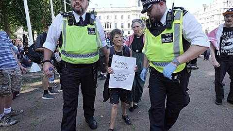 A woman is detained by police officers as supporters of Palestine Action take part in a mass action in London in August 2025.