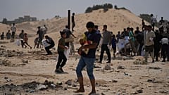 الفلسطينيون يجمعون حزم مساعدات إنسانية من الإمارات العربية المتحدة بعد أن تم إنزالهم جوا إلى دير البلح, في وسط قطاع غزة, يوم السبت, أغسطس. 9, 2025