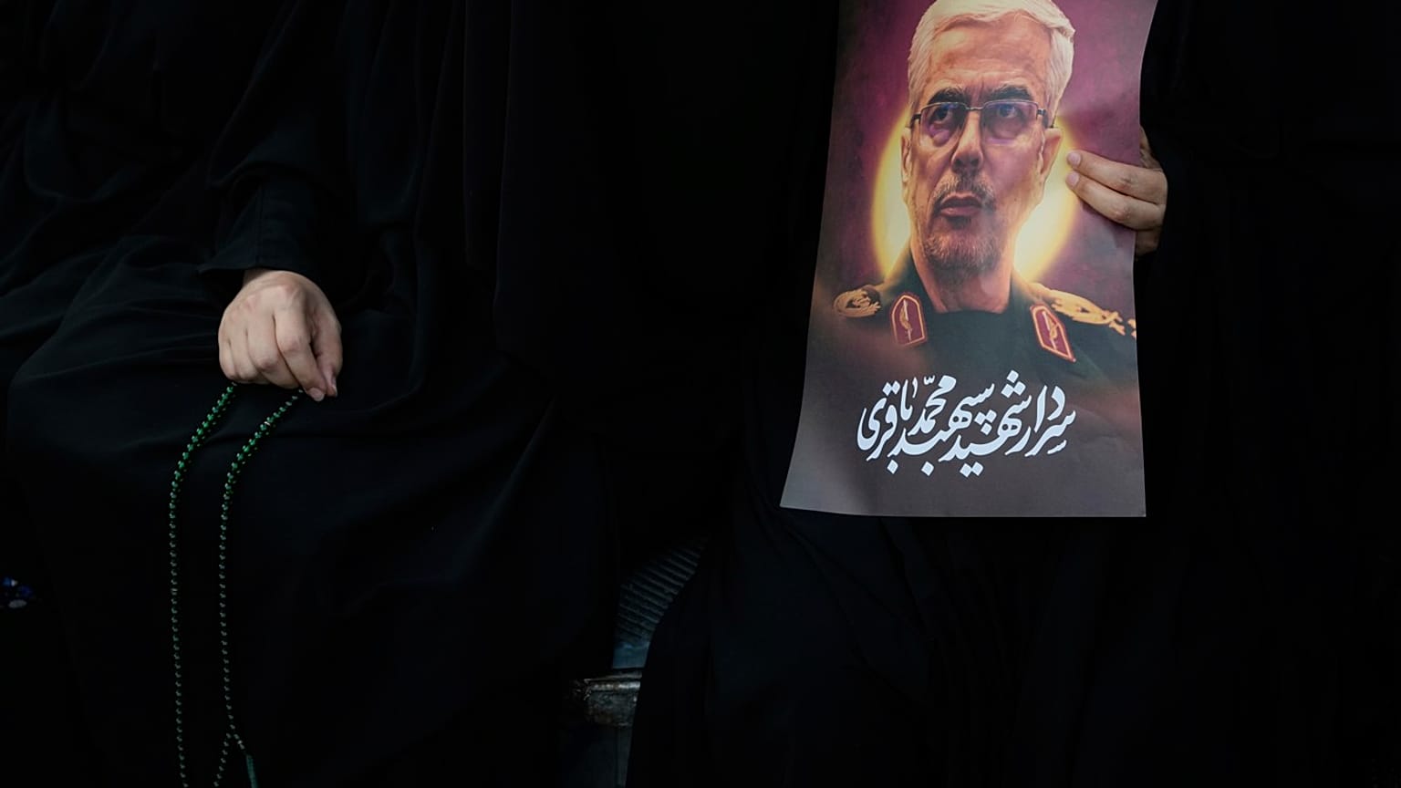 امرأة إيرانية تحمل صورة الجنرال محمد حسين باقري الذي قُتل في غارة إسرائيلية، إيران، الثلاثاء 24 يونيو/حزيران 2025. 