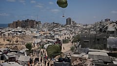 الفلسطينيون يسارعون لجمع المساعدات الإنسانية التي تنزلها المظلات جوا إلى مدينة غزة, شمال قطاع غزة,أغسطس. 7, 2025. 