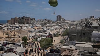 الفلسطينيون يسارعون لجمع المساعدات الإنسانية التي تنزلها المظلات جوا إلى مدينة غزة, شمال قطاع غزة,أغسطس. 7, 2025. 
