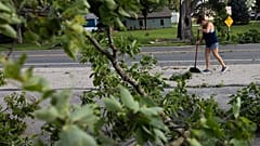 Dawn Sands limpia los escombros de Goddard Street en French Island tras una tormenta con vientos extremos en La Crosse, Wisconsin, el martes 29 de julio de 2025. (Saskia Hatvany/La Crosse Tribune vía