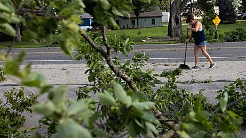 Dawn Sands cleans debris off Goddard Street on French Island after a storm with extreme winds in La Crosse, Wis., Tuesday, July 29, 2025. (Saskia Hatvany/La Crosse Tribune via