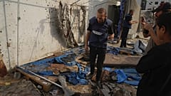 فلسطينيون يتفقدون الخيمة المدمرة التي قُتل فيها الصحفيون، بمن فيهم مراسلا الجزيرة أنس الشريف ومحمد قريقع، في غارة جوية إسرائيلية في مدينة غزة, الاثنين 11 أغسطس/ آب 2025.