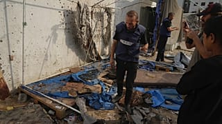 فلسطينيون يتفقدون الخيمة المدمرة التي قُتل فيها الصحفيون، بمن فيهم مراسلا الجزيرة أنس الشريف ومحمد قريقع، في غارة جوية إسرائيلية في مدينة غزة, الاثنين 11 أغسطس/ آب 2025.