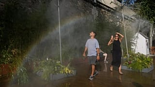 People cool off under showers at Paris Plage along the Seine river in Paris, 10 August 2025.
