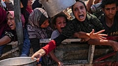 فلسطينيون يحاولون الحصول على طعام في مطبخ مجتمعي بمدينة غزة، 4 آب 2025.     