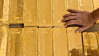 a person touches gold bars in the gold store of the Cantonal Bank of Zurich