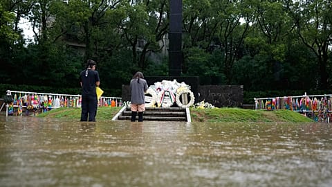 Two people pray knee-deep in water at a memorial to honour the victims of the atomic bombing at Nagasaki, 9 August, 2025