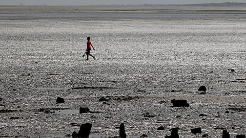A holiday maker enjoys the beach in Leysdown On Sea in Kent, 4 August 2015.