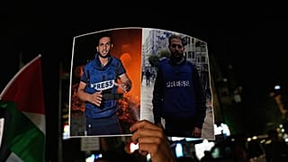 امرأة تحمل لافتة تظهر الصحفيين الفلسطينيين أنس الشريف ومحمد قريقة، اللذين قتلتهما إسرائيل في غارة بغزة، خلال مظاهرة برام الله، 11 أغسطس 2025