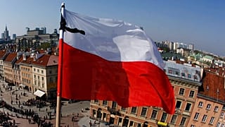 FILE: Thousands of people line up underneath the Polish national flag near the Presidential Palace in Warsaw, Thursday, April 15, 2010,