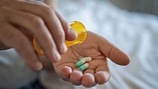 Une personne se prépare à prendre un médicament.