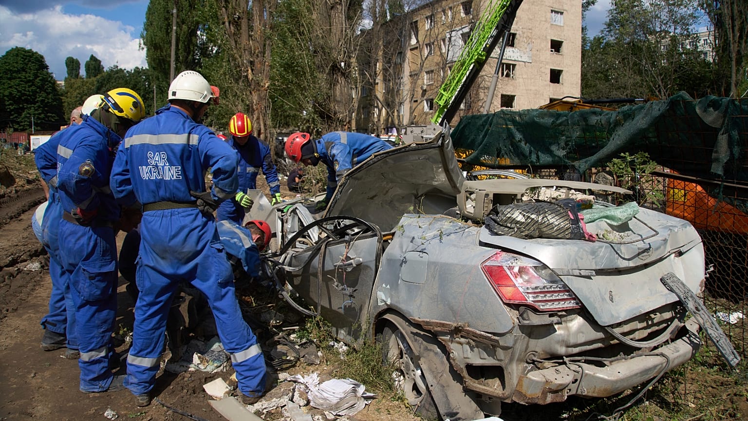FILE: Emergency workers inspect a damaged car close to the multi-storey residential house struck by a Russian missile killing 31 civilians, in Kyiv, 1 August 2025